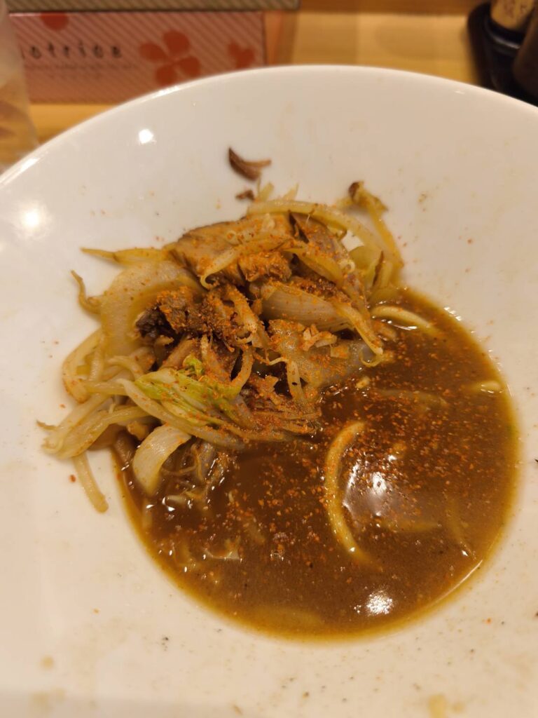 大宮 蕾 本家の野菜つけ麺のつけ汁に唐辛子を足した様子