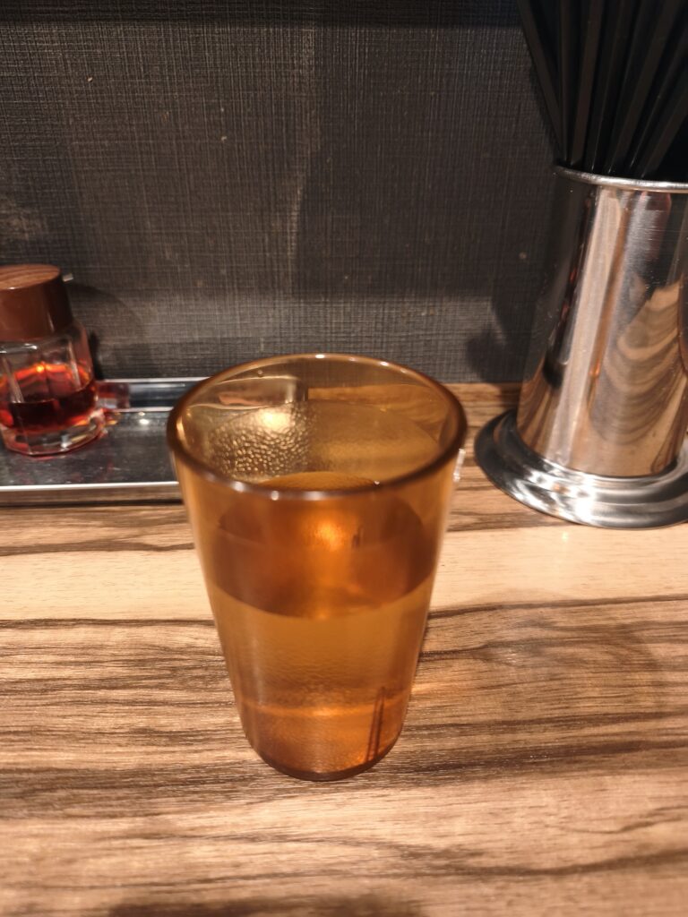 石川家大宮店のカウンターに置かれた、冷たい水の入ったプラスチックのコップ
