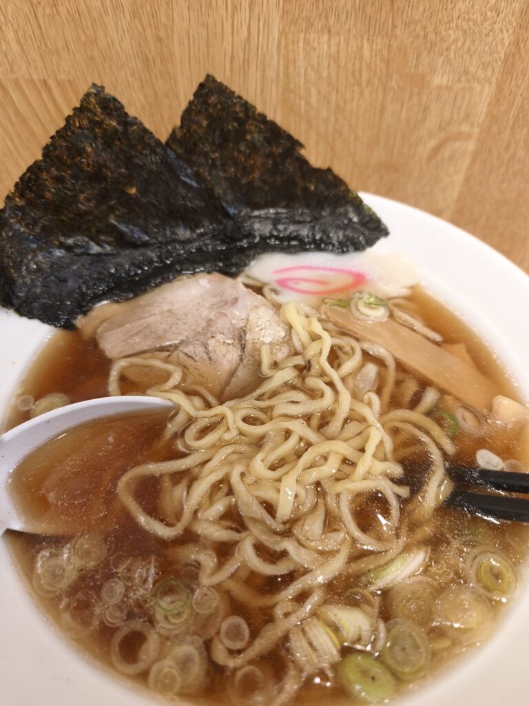 佐野ラーメンに白胡椒をふりかけて味変している様子