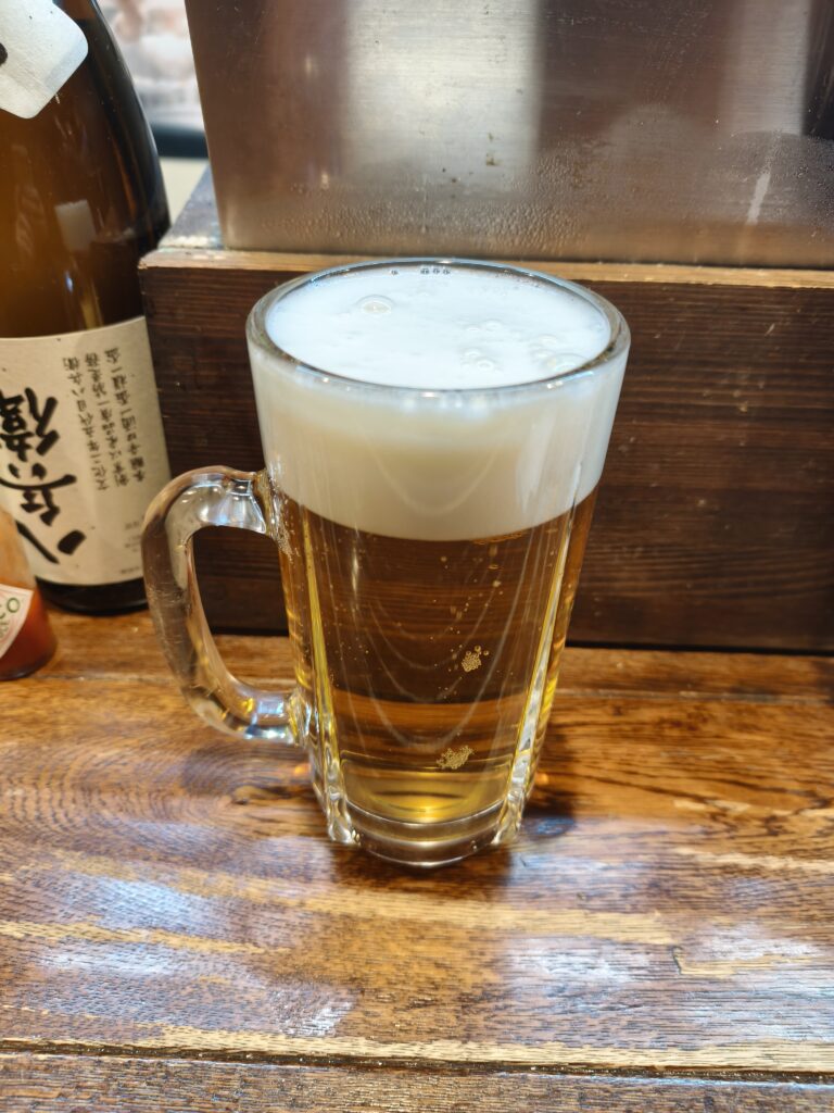 冷えたジョッキに注がれた黄金色の生ビール。泡が美しく乗っている。