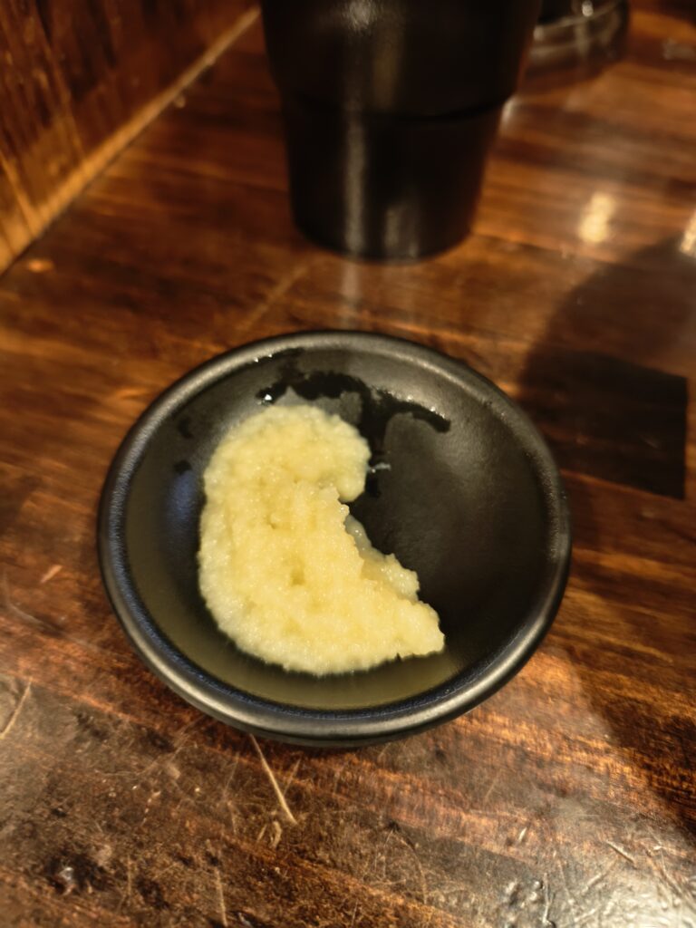 みそらーめんに新鮮な生ニンニクを絞り入れている様子。